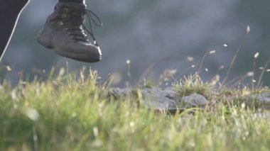 Yavaş hareket yakından: Dağcılık tanınmaz halde bizzat dik kayalık dağ aşağı iz kapalı güzel güneşli yaz gününde yürüme bot. Alpler keşfetmek maceraya yürüyüş ayakkabıları içinde kadın