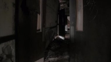 FPV, Close Up: terk edilmiş çürüyen psikiyatrik hastane karanlık dar koridor boyunca yürüyüş. Yıpranmış ahşap kapılar taşıma ve ufalanan duvarlarda kırık uğursuz sanatoryum kaçış için arıyorsunuz