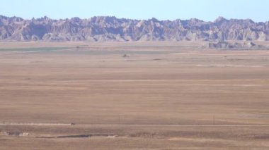 Hava: rocky Badlands peyzaj tozlu Çölü güneşli günde araba araba. Badlands çayır Güney Dakota, Amerika Birleşik Devletleri ile tozlu toprak yol boyunca sürüş gümüş kişisel araç