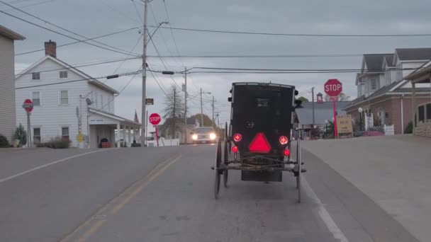 美国米尔斯堡 2016年10月18日 在风景秀丽的乡村小镇 阿米什老式马车沿着街道行驶的后部视野 门诺派在老式货车转向在路口 — 图库视频影像