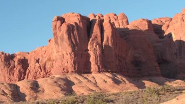 Yakın: kırmızı kaya oluşumları Arches National Park Utah ABD güneşli sabahı çarpıcı. Uzaydan kumtaşı sütunlar, windows ve kemerler manzara oluşumu sıcak çölde gün batımında.