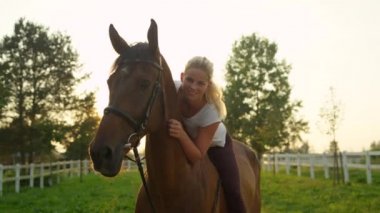 Ağır çekim, Close Up, Dof: Güzel sarışın kız sürme ve onun sevgili mare günbatımında kucaklayan eyersiz portresi. Kadın Binicilik çarpıcı ata sakin güneşli yaz sabahı güzel