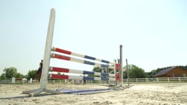 Ağır çekim, Close Up, düşük görüş açısı: kız güzel koyu kahverengi iğdiş edilmiş hayvan atlama show yarışmanın tesisi. Demiryolu vurma ve engel atlamak çalışırken başarısız büyük at