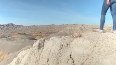Yakın: Genç erkek solo Badlands ulusal park yürüyüş ve kayalık dağ sivri kumtaşı mountaintops bakan üst ulaşan gezgin. Trekking, manzaranın neşeli kadın turist