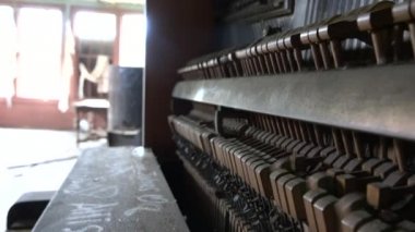 Yakın kadar Dof içinden tozlu piyano dağılan eski. Bir piyano tuşuna basıldığında notu üretmek için ayarlanmış dizeleri çarpıcı çekiç. Müzik eski terk edilmiş yıkık evinde tozlu dikey piyano