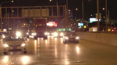 Chicago, Amerika Birleşik Devletleri - 20 Ekim 2016: Fpv arabalar, SUV'lar ve yarı römork kamyon meşgul yoğun trafik eyaletler arası karayolu üzerinde sürme. Gece gökdelenler ve ikonik Chicago döngü manzarası, arka planda yaktı