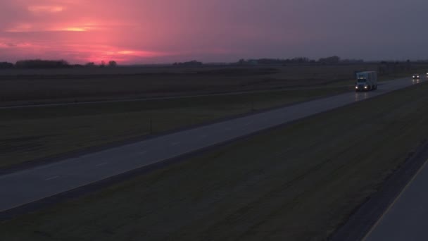 マンケート アメリカ合衆国 2016 航空クローズ アップ 日の出物資の輸送 忙しい高速道路に沿って運転フェデックスのトラックの上を飛んでします フェデックス半トラック輸送とピンクの日没時配信 — ストック動画