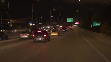 Chicago, Amerika Birleşik Devletleri - 20 Ekim 2016: Fpv sürüş araba ikonik Chicago şehir manzarası gökdelenler ile doğru birden çok şeritli otoyol boyunca doğrultusunda gece yaktı. Meşgul otoyol üzerinde trafik sıkışıklığı