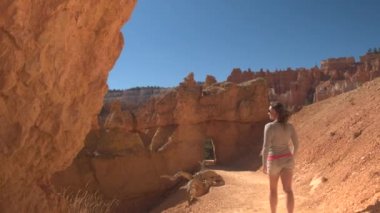 Bryce Canyon Milli Parkı güneşli Utah çarpıcı keşfetmek boş bir yol boyunca yürüyüş mutlu kadın uzun yürüyüşe çıkan kimse. Bryce Canyon bir iz hiking genç kadın turist Milli Parklar ve yerler ziyaret