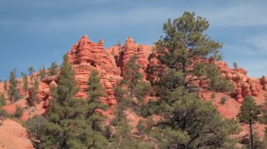Yakın: Yüksek kırmızı rock kayalıklarla ve Hudu ayağı önünde inanılmaz Bryce Canyon Milli Parkı güneşli Utah, ABD. Kırmızı kum çöl ve kumtaşı erozyon oluşumları Bryce Np arasında sürüş