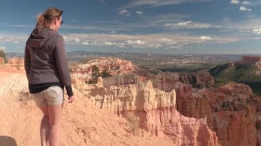 Kumtaşı Hudu oluşumları bakış açısı Bryce Canyon Milli Parkı'nda Utah, hayran boş yol yürüme genç kadın uzun yürüyüşe çıkan kimse. Genç kadın turist tozlu yolun Bryce Canyon çölde ABD hiking