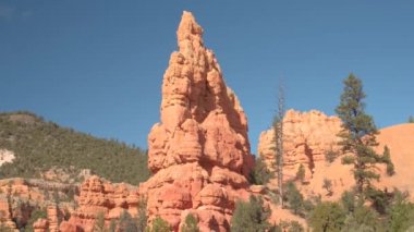 Yakın: Yüksek kırmızı rock kayalıklarla ve Hudu ayağı önünde inanılmaz Bryce Canyon Milli Parkı güneşli Utah, ABD. Kırmızı kum çöl ve kumtaşı erozyon oluşumları Bryce Np arasında sürüş