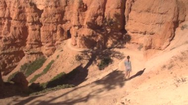 Neşeli kadın uzun yürüyüşe çıkan kimse Bryce Canyon Milli Parkı güneşli Utah çarpıcı keşfetmek boş bir yol boyunca yürüyüş. Bryce Canyon, bir iz hiking genç kadın turist Milli Parklar ve yerler ziyaret
