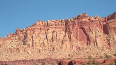 Yakın: Sürüş geçmiş büyük rocky Dağları kırmızı rock çölde sıcak yaz gününde aşınmış. Kayalık dağ oluşumları Utah, Amerika Birleşik Devletleri geçmiş sürüş. Güneşli Capitol resif kuru çöl peyzaj