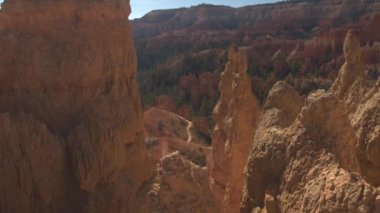 Uzakta Bryce Canyon Milli Parkı güneşli günde iki tanınmaz turistler. Seyahat etmek ve yürüyüş parkurları ve Utah, Amerika Birleşik Devletleri çarpıcı parkı keşfetmek ziyaretçiler