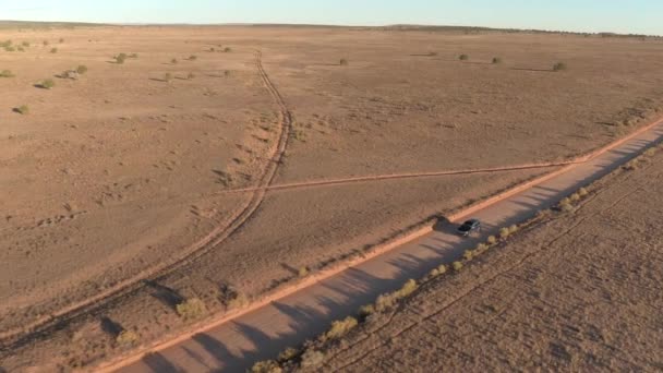 Suv 汽车在犹他州干燥的草地沙漠山谷中沿着尘土飞扬的空旷道路行驶 在金色日落时 乘坐吉普车在直达土路线上进入国会礁 — 图库视频影像