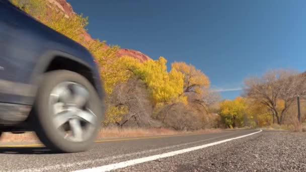 航空写真 上を飛んでトラフィックの完全な複数車線の幹線道路は 晴れた日に広大な秋の紅葉林に覆われた山岳風景を湾曲します 丘陵の道道旅行車 — ストック動画