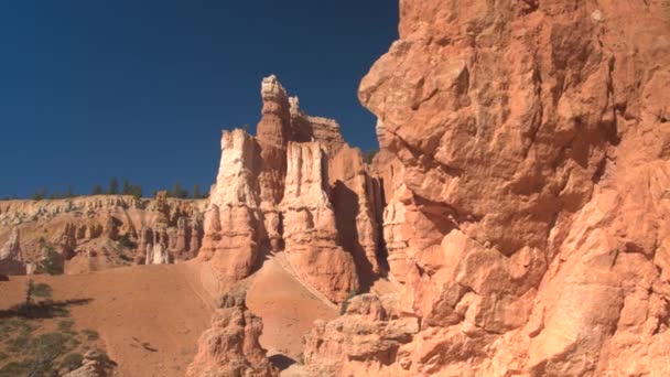 クローズ アップは 晴れた日に豪華な侵食の赤い岩の景観ブライスキャニオン国立公園の見事な 米国ユタ州の砂漠の美しい柱とホードー砂岩赤砂で青い空を背景 — ストック動画