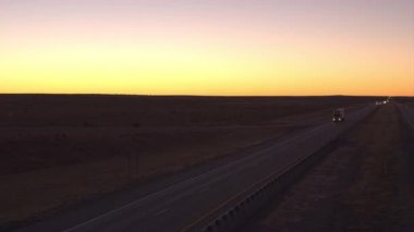 Hava yakın: otomobil ve navlun yarı kamyon dolu boş bir karayolu boyunca sürüş mal ile sabah şafak kargo taşıma. Konteyner kamyon teslim taşıyıcı kargo altın günbatımında çekme