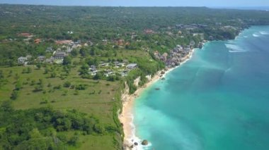 Hava: Bali Adası, Endonezya çarpıcı derin mavi okyanus üzerinde yükselen yemyeşil yeşil cliffy kıyı şeridi üzerinde uçan. Lüks Bungalov ve dubleks sonsuzluk havuzları denizin kenarında turist Resort