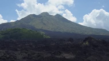 Hava Zoom-In etkisi taşlı siyah lav engebeli ve Mount Batur toot dağ silsilesi zirvesine doğru gri küllü volkanik toprak. Kintamani yanardağ krater, Bali, dramatik peyzaj