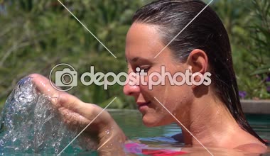 Ağır çekim yakın kadar oldukça genç kız rahatlatıcı açık lüks ve spa tatil beldesine güneşli Bali tropikal orman. Yüzünde, ıslak saçlarını düşen waterdrops serinletici su sıçramasına kadın