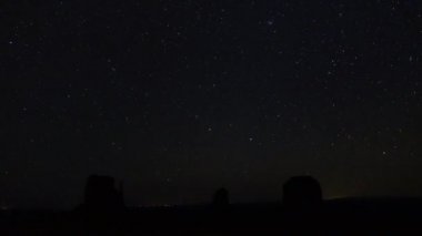 Gece gökyüzü zaman atlamalı: Monument Valley landmark Utah ABD, yıldızlı gece inanılmaz. Yıldızlar ve galaksiler mesa dağlardaki yukarıda dönen milyonlarca gökyüzü temizleyin. Yıldız, meteor, göktaşları ve uçağı