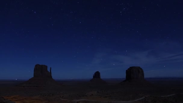 夜の空時間の経過 アメリカ合衆国ユタ州のモニュメント バレー ランドマークで星空を驚くほどです 何百万もの星や銀河にメサ山々 の上回転は澄んだ空です 流れ星とジェット — ストック動画