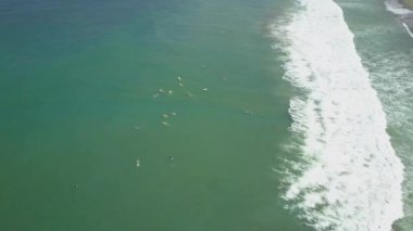 Hava: acemi sörfçü büyük sörf tahtaları ve longboards güneşli sörf, sörf öğrenmek yukarıda uçan. Sörfçü alıcı kırma dalgalar okyanusta kalabalıklar. Bali Adası'nda yaz tatilde insanlar