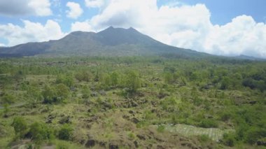 Hava: Otomobil, motosiklet taşlı aracılığıyla karayolu üzerinde sürüş Mount Batur Dağı'nda yemyeşil ağaçlarla kaplı lav manzara siyah. Kintamani yol kayalık volkanik arazi volkan caldera lider