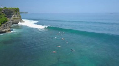 Hava: Yeni başlayanlar ve profesyonel sörfçüler sanatçısını kalabalık güneşli Bali bir dalga yakalamak için bekleyen. Yüzme, kürek çekmeye ve kristal açık denizde sörf yaz tatilde tanınmayan insanlar