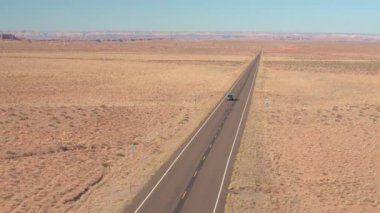Hava: Utah flatlands, ABD bir boş yol yalak kumtaşı çölde boyunca bir siyah Suv araba yukarıda uçan. İnsanlar üzerinde yalak çöl manzara yerel otoyol güneşli günde seyahat yolculuğa.