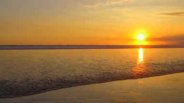 Yakın: güzel kumlu plajı muhteşem altın ışık günbatımında yıkama sahil seyahat nazik kristal berraklığında dalgalı dalga. Sarı güneş ayarı okyanus ufuk arkasında. Çarpıcı tropikal plaj
