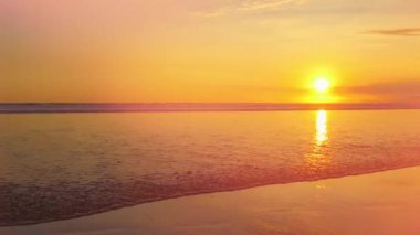 Yakın: güzel kumlu plajı muhteşem altın ışık günbatımında yıkama sahil seyahat nazik kristal berraklığında dalgalı dalga. Sarı güneş ayarı okyanus ufuk arkasında. Çarpıcı tropikal plaj