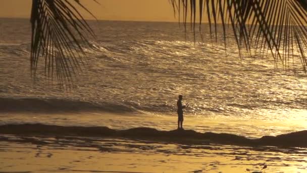 Low Motion Silhouette Pescador Recreativo Recife Rochoso Pelo Mar Ondulante — Vídeo de Stock