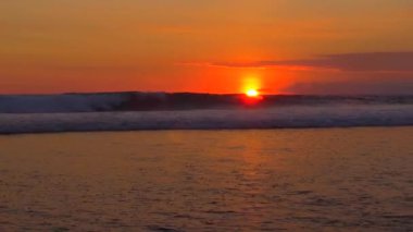 Kırma ve rüya gibi Bali Adası, Endonezya, şenlik ateşi-kırmızı günbatımı sakin yaz akşamı deniz sahile doğru haddeleme sonu dalgalar sörf. Derin mavi deniz altın ışık günbatımında sıçramasına dalgalanan