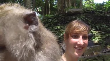Kadar yakın, Selfie: Neşeli genç kadın maymun ormanı maceracı turistik Tur Ubud, Bali meraklı şebeği ile komik selfie yapıyor. Bali dili macaca meraklı maymun ve gülümseyen kız ormanda
