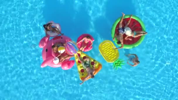 하향식 친구와 수영장에서 튜브에 공을가지고 파인애플 플라밍고 도넛형 수레에 즐기는 — 비디오