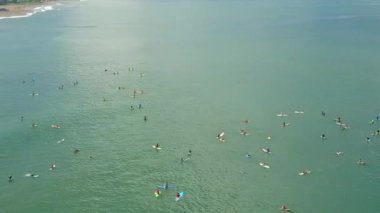 Hava, yakın: Sörfçü için popüler sörf Canggu kumlu plaj, Bali, Endonezya kalabalık sanatçısını dışarı kürek çekmeye sörf tahtaları üzerinde. Zümrüt Okyanusu yakın turistik tatil tatil günlerinde insanların kalabalıklar