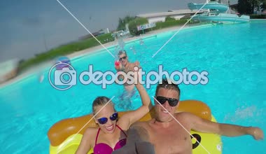 Lens Flare Selfie: gençlerin zevk gülümseyen mutlu çocuk watergun kavga sıçramasına sahip renkli floaties havuz partisinde üzerinde karpuz şişme pizzaya, flamingo, su ve halka yüzen