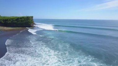 Anteni: köpüklü dalgalar güzel kayalık Plajı uzun boylu cliffy duvara kırma yıkama. Okyanus su yüzeyi üzerinde yükselen kaya zor. İnsanlar derin mavi denizde güneşli yaz gününde Bali yüzme.