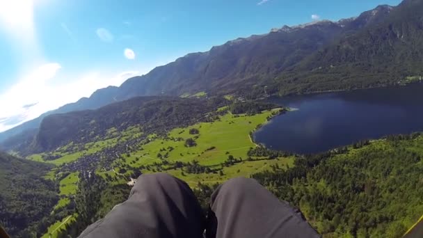 POV: Parapendio che vola sopra la splendida campagna tra le montagne nella giornata di sole — Video Stock