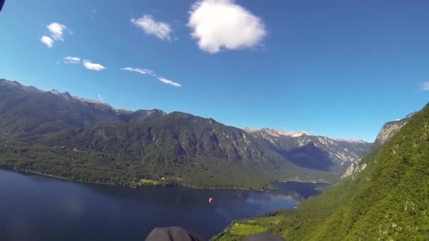 POV: paralotniarstwo paralotniarstwo nad wspaniałą zieloną górską doliną i błękitnym jeziorem — Wideo stockowe