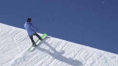 Ağır çekim: büyük dağ kar Park'ta yarım boru sürme, halfpipe duvardan ve güneş üzerinde atlama, hile ve rotasyonlar kapmak ile güneşli kışın gerçekleştirme genç pro snowboarder