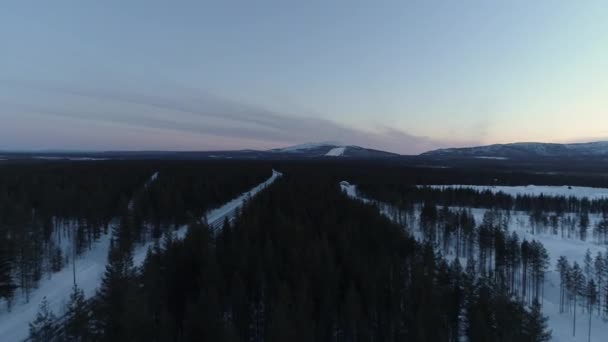 在松树林上朝向利维山度假村和滑雪场 雪滑道准备在天黑后夜间滑雪 完美梳理的滑雪胜地利维 芬兰夜间滑雪灯照亮 — 图库视频影像