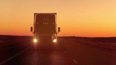 Mercek parlaması yakından: sürüş ve boş karayolu üzerinde ürünler Great Plains altın sabah çekme yarı kamyon. Yük kamyon kargo Interstate karayolunda çarpıcı günbatımında taşıma