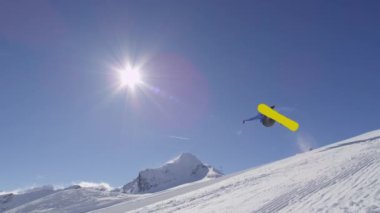 Ağır çekim: büyük dağ kar Park'ta yarım boru sürme, yüksek halfpipe duvardan atlama, hile ve rotasyonlar kapmak ile güneşli kışın gerçekleştirme genç pro snowboarder