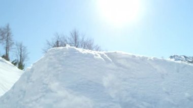 Ağır çekim: güneşli dağ kar parkta sürme ve güneşli kışın büyük hava kicker atlama Extreme snowboard adam. Güneşin atlama genç pro snowboarder