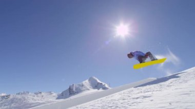Ağır çekim: büyük dağ kar Park'ta yarım boru sürme, halfpipe duvardan ve güneş üzerinde atlama, hile ve rotasyonlar kapmak ile güneşli kışın gerçekleştirme genç pro snowboarder