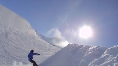 Ağır çekim: güneşli kışın güneşin halfpipe duvar üzerinden yapmak püskürtme hüner büyük dağ kar Park, yarım boru sürme genç pro snowboarder